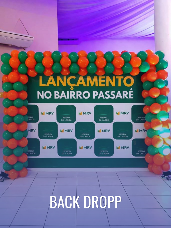Painel de fotos tipo backdrop personalizado com arco de balões nas cores verde e laranja para lançamento imobiliário. Serviço de estrutura para eventos corporativos e ativações de marca da Agência Blue PRO em Fortaleza.